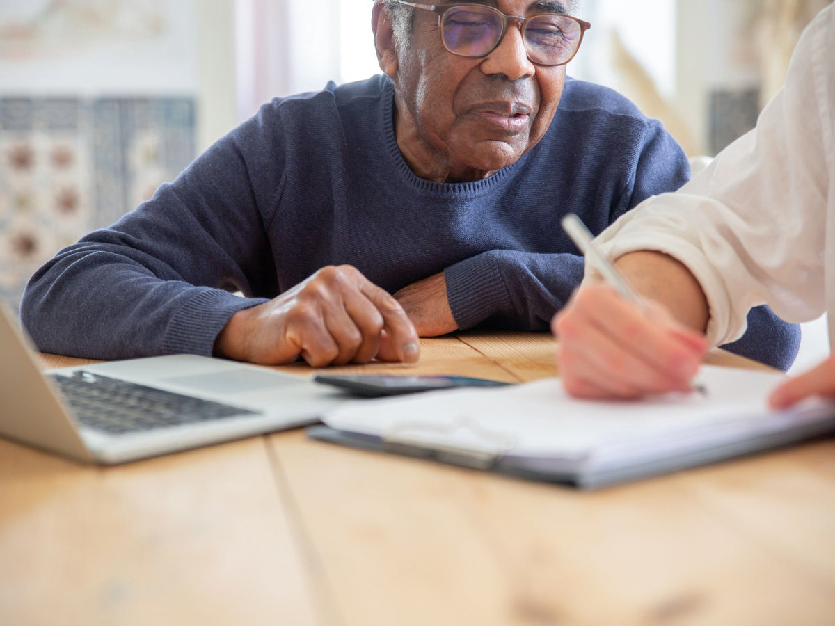 Older adult receiving practical support with paperwork at home